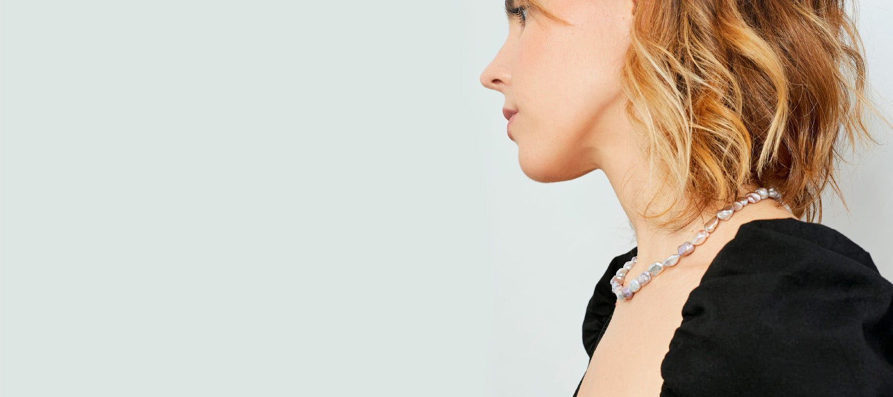 Mujer con collar de perlas cultivadas color rosa