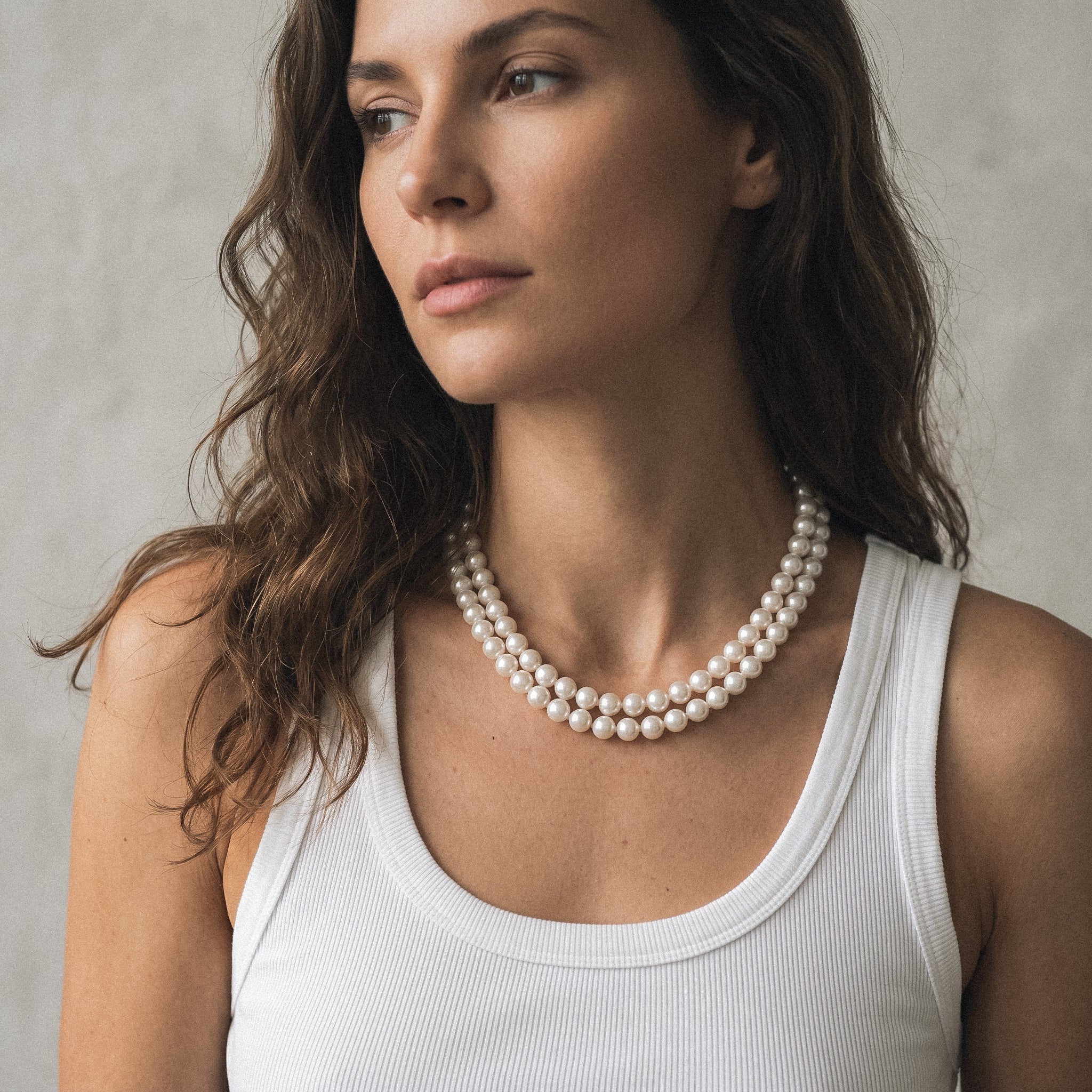 mujer con collares de perlas cultivadas redondas